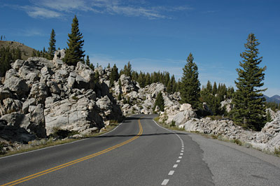 Page iv photo. This image shows a two lane road passing through very rocky terrain. 