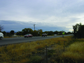 Two photos showing views of roadways from the Santa Clara Pueblo RSA site. Photo 1 is looking south along NM 30 toward a signed and marked school zone crosswalk near the Pueblo's main residential area.