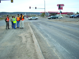Two photos showing views of roadways from the Navajo Nation RSA site. Photo 1 is looking north along N12 at the intersection with N110 (near Fort Defiance). A 62-foot urban cross-section is provided, consisting of two through lanes in each direction, with curb and gutter and turn lanes (or a raised median) at intersections.