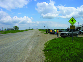 Four photos showing views roadways from the Standing Rock Sioux Tribe RSA. Photo 1 is of an intersection with a pedestrian crossing warning sign.