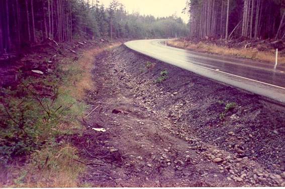 photo of horizontal curve with steep slope immediately adjacent to pavement and erosion is undermining the shoulder.