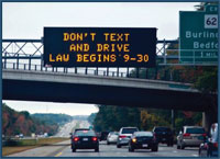 Photo of a dynamic message sign with the word don’t text and drive displayed.