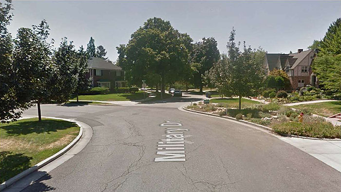Figure 3.6.2. Realigned Intersection in Residential Area. This figure contains a photograph of a street labeled Military Drive. The street curves to the left and another street curves off of it to the right, creating a three way intersection. The streets are all tree lined.