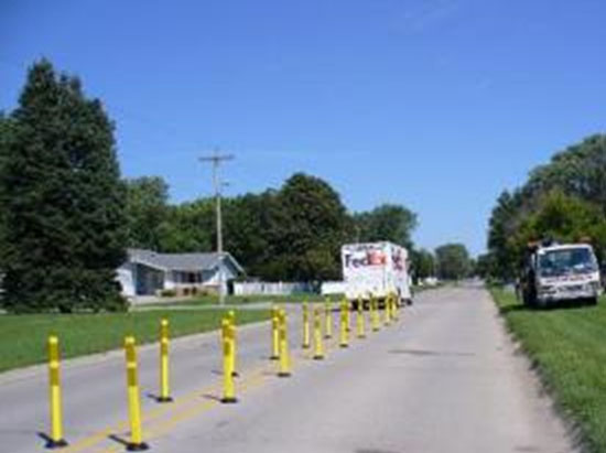 Figure 3-5 Treatment in Slater, Iowa. (Image Source: Neal Hawkins). This photo shows a FedEx truck driving on a road with tubular channelizers installed as road treatment.