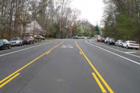 Photo shows two-way left turn lane in the middle of a road.