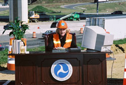 Administrator Mary E. Peters speaking from an outdoor desk next to I-95 in Virginia