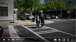 Screenshot of video shows two pedestrians in a crosswalk.