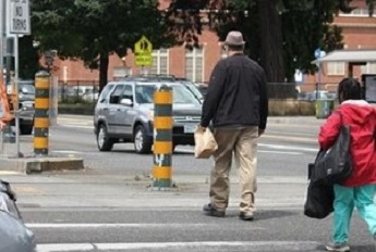 Photo shows Interstate Avenue in Portland where pedestrians are crossing the street at a crosswalk.